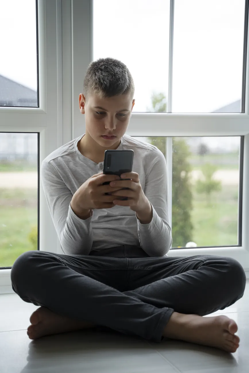 jongen met smartphone in de hand, van voren gezien